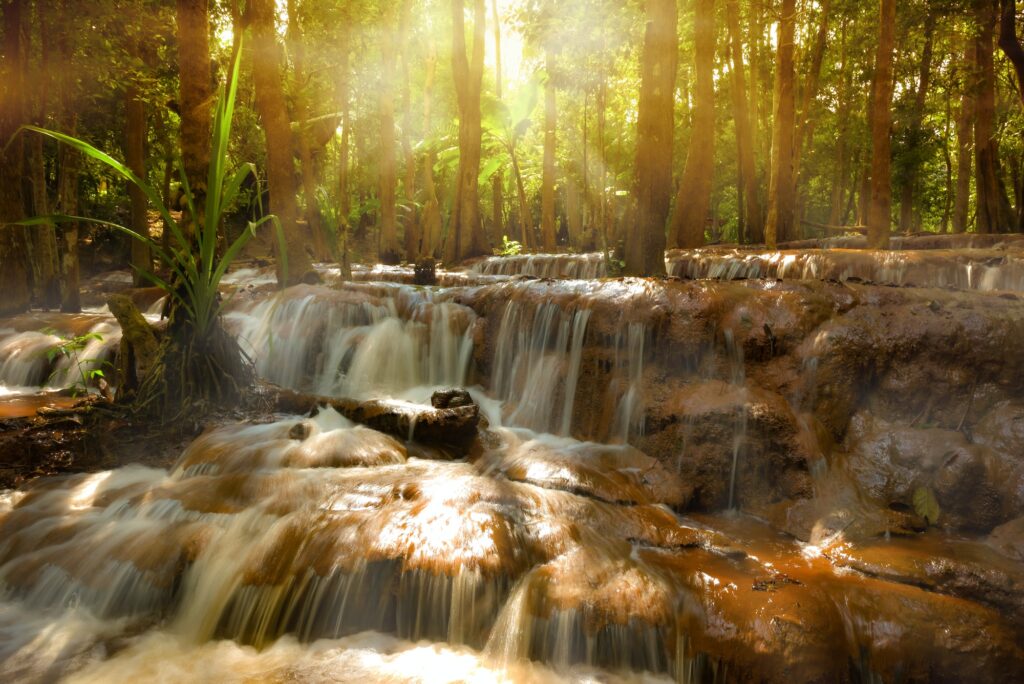 Pa Wai Waterfall with sun rays shining through the trees, Tak Thailand